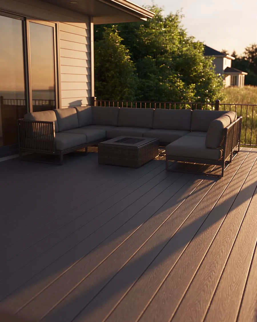 Composite deck with an outdoor sectional and fire table at sunset